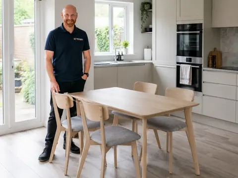 Mark beside an assembled kitchen dining table and chairs